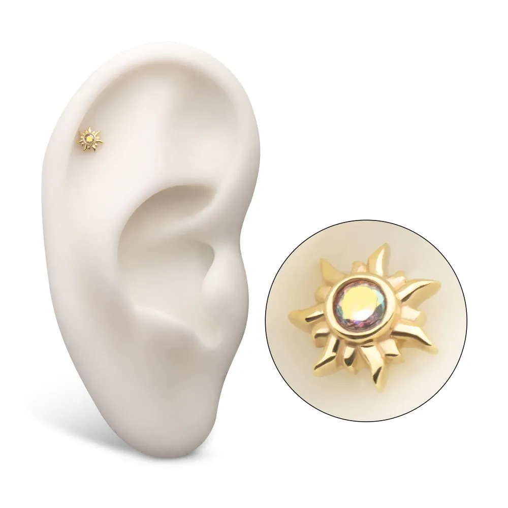 A 14k yellow gold stud earring with a multicolored gemstone in the center, designed for threadless piercings. Shown in the helix piercing of a model ear.